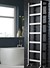 Heated towel rail on black tiles