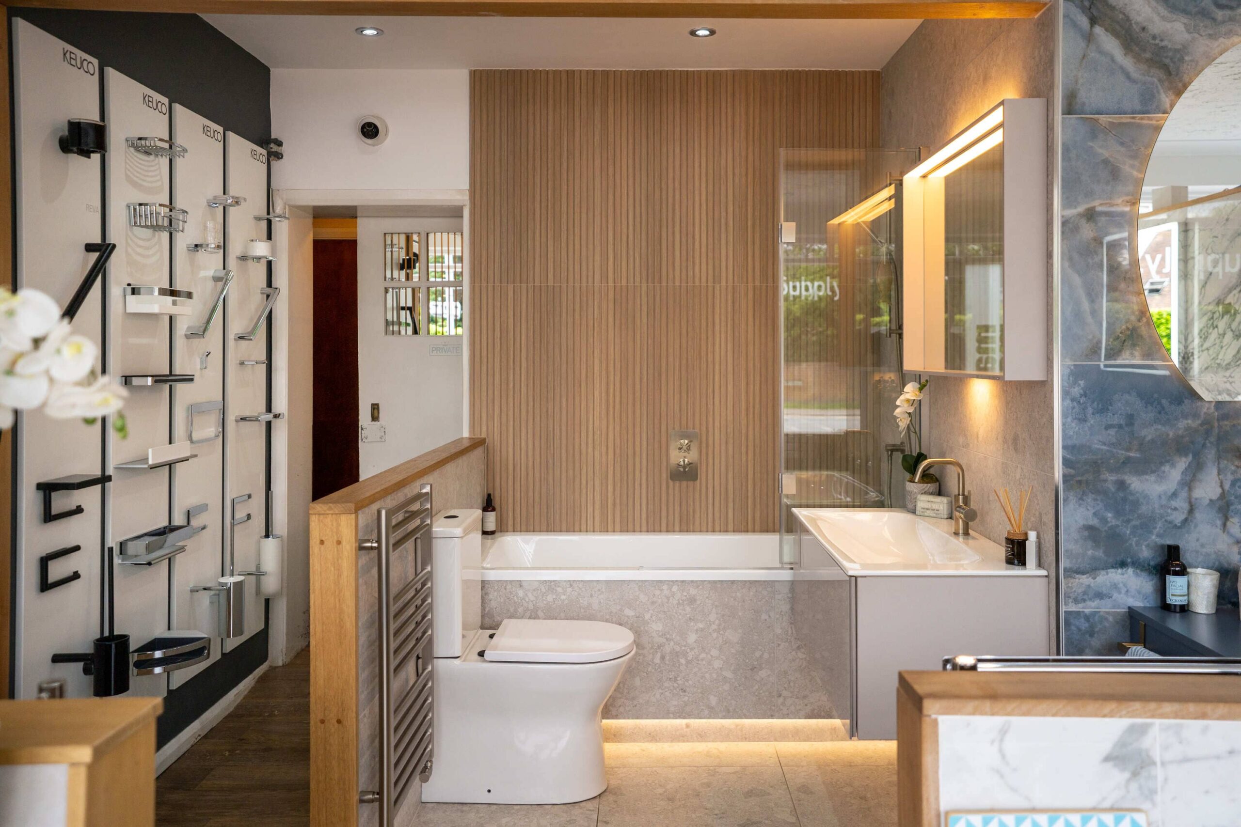 Modern Imperial Bathrooms showroom display with a bath, toilet, vanity unit and brass fittings