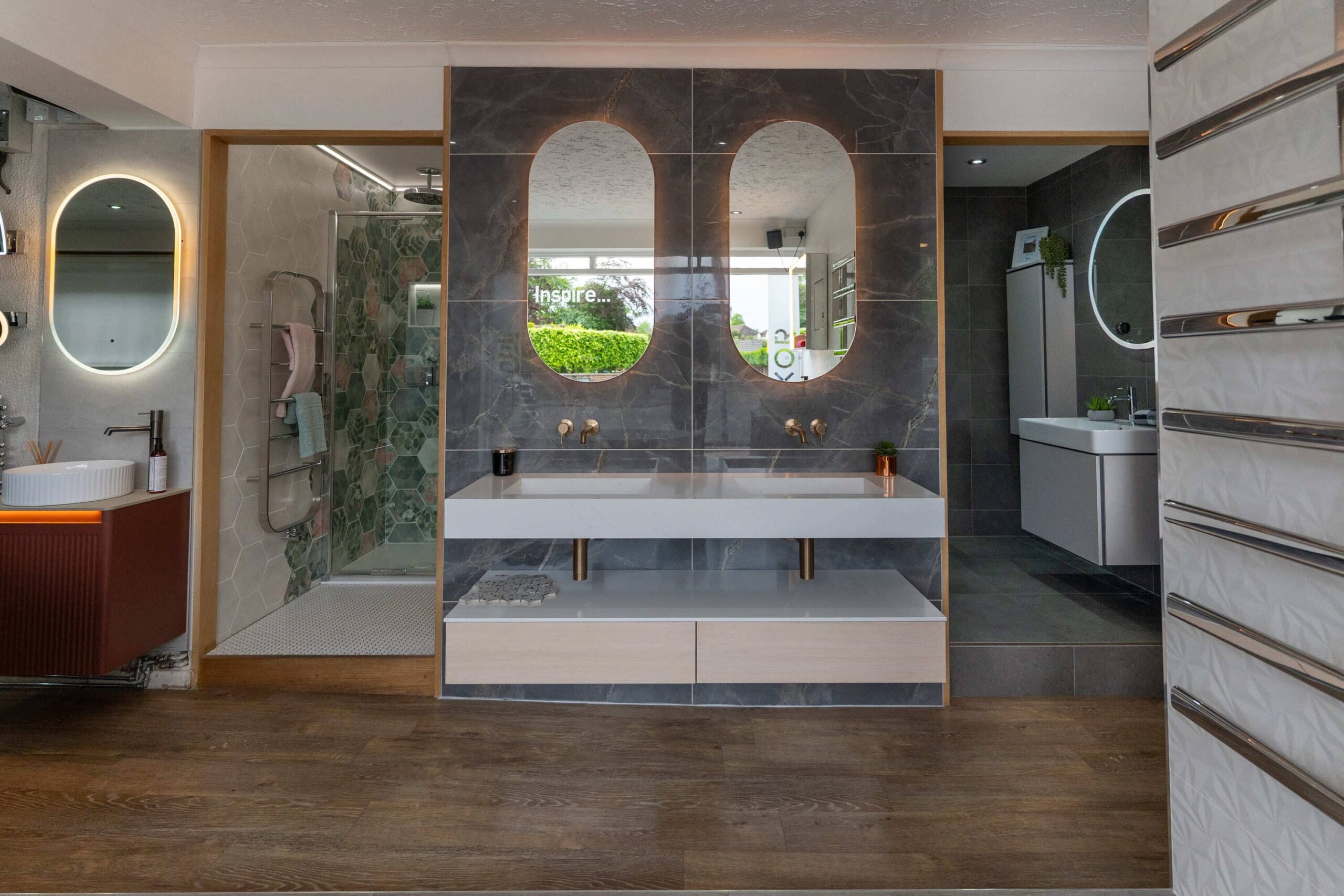 Wet room showroom display with an open shower area, double vanity and illuminated mirrors